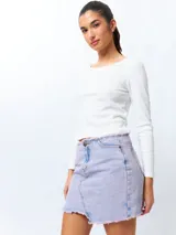 Minifalda de jean negra con corte asimétrico en el frente y deflecado tanto en la cintura como en el ruedo.