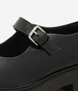 Zapato estilo Mary Jane de la marca Satinato, color negro, confeccionado en poliuretano con suela tractorada de goma, punta redonda y tira en el empeine con hebilla metálica ajustable.