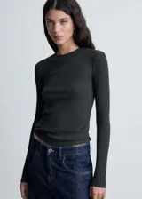 Camiseta negra de tejido de punto de canalé, con cuello redondo, corte ajustado y mangas largas.