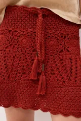 Minifalda celeste tejida al crochet con lurex plateado, cintura con cordón ajustable y diseño calado.