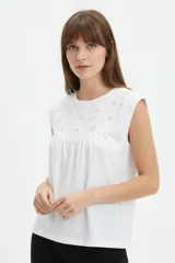 Musculosa de algodón blanca con cuello redondo y detalle de bordado en el canesú delantero.