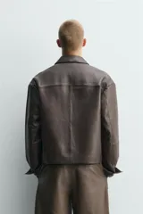 Cazadora de cuero con acabado napado, corte boxy fit, cuello solapa, manga larga y cierre frontal con botones. Cuenta con bolsillos laterales y bolsillo interior.