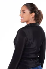 Camisa negra plisada con escote en V y cierre frontal con tres botones.