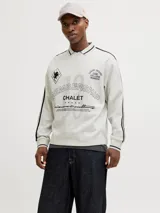 Buzo de manga larga color gris melange, con cuello tipo polo y ajuste holgado. Presenta estampado gráfico frontal con tipografía y detalles en negro, además de bandas laterales en las mangas.