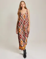 Vestido largo sin mangas con escote redondo, confeccionado en viscosa con un estampado geométrico tipo ikat en tonos marrones, naranjas y blancos, con detalle de texto en el ruedo.