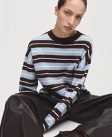 Sweater de punto fino con diseño oversize y patrón de rayas horizontales en tonos marrón, celeste y blanco. Cuenta con cuello redondo y mangas largas.
