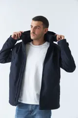 Campera negra para hombre con capucha ajustable y bolsillos con botones.