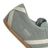 Championes Adidas Tokyo de perfil bajo, confeccionados en gamuza color verde con detalles en blanco y suela de goma marrón. Presentan las clásicas tres tiras laterales y la inscripción 'adidas TOKYO' estampada en dorado.