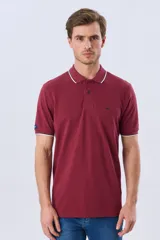 Remera polo de piqué azul marino, con cuello y puños de mangas cortas con ribete blanco en contraste, cierre frontal de dos botones y pequeño logo bordado en el pecho.
