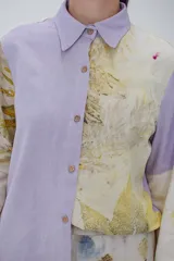 Camisa con cuello camisero, lazos para ajustar en puños y cartera con botones de madera. Diseño con paneles de color lila y estampado de hojas.