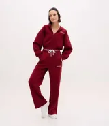 Pantalón deportivo de corte recto, confeccionado en tejido de microfibra color bordó. Presenta cintura elástica con cordón ajustable, bolsillos delanteros embutidos y detalle de bordado discreto en la pierna.