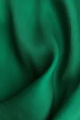 Vestido corto verde esmeralda sin mangas, con escote redondo y costura diagonal que define la cintura, creando una falda evasé.