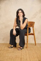 Pantalón de vestir negro de corte ancho y tiro alto, con diseño pinzado en la cintura.