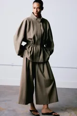 Pantalón culotte de tiro medio, con diseño de pierna ancha y pliegues frontales. Cuenta con cintura ajustable mediante cordones, bolsillos laterales y cierre frontal con cremallera y gancho metálico.