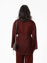 Kimono largo de terciopelo negro, con mangas largas y diseño abierto. Confeccionado en una mezcla de viscosa y poliamida, ofrece una caída fluida y elegante.