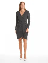 Vestido corto de seda fría con estampado botánico en blanco y negro. Presenta escote en V cruzado, mangas largas entalladas, cintura elastizada con aplique metálico lateral y ruedo asimétrico.