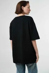 Remera de algodón gris melange con corte oversize, manga corta y estampa localizada en el frente con motivos deportivos en tonos verde y rosado.