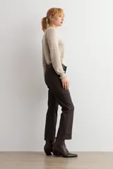 Pantalón de corte cropped y tiro alto, con acabado engomado en color chocolate. Presenta diseño de cinco bolsillos y cierre frontal con botón y cremallera.