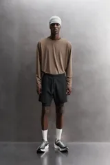 Shorts de entrenamiento azul marino con calza interior negra. Cintura elástica ajustable con cordón, bolsillos laterales con cierre y aberturas laterales en el bajo.