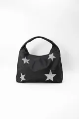 Cartera negra con diseño de estrellas plateadas brillantes. Tiene un asa ancha para llevar al hombro.