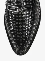 Mocasín negro de cuero con plataforma gruesa y apliques de tachas metálicas plateadas en toda la superficie superior y el borde de la plataforma. Presenta un detalle de hebilla metálica en el empeine.