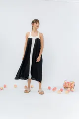 Vestido midi negro con panel frontal blanco, de corte amplio, escote recto y tiras anchas.