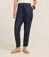 Pantalón baggy de jean azul oscuro, de tiro alto con cintura elástica fruncida y lazo para ajuste. Presenta bolsillos laterales y dobladillos con vuelta en los tobillos.