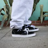 Championes Vans Authentic de lona color negro con suela de goma blanca.