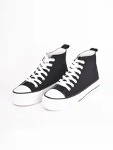 Zapatilla de caña alta con plataforma, confeccionada en lona negra con cordones y puntera de goma blanca.