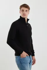 Sweater verde de punto inglés con cuello alto y cierre metálico frontal. Tiene mangas largas y terminaciones en punto canalé.