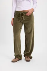 Pantalon de tiro bajo confeccionado en tejido de terciopelo color verde oliva, con corte recto y holgado. Presenta cintura ajustable con cordón y elástico en la parte trasera de la pretina.