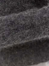 Polera azul de tejido suave con cuello alto y manga larga. Tiene un pequeño bordado en el frente y otro en la manga.