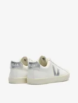 Championes Veja modelo Esplar, de diseño minimalista en color blanco con detalles metalizados plateados en el logo lateral y el talón. Presentan cierre de cordones y suela de goma en tono crema.