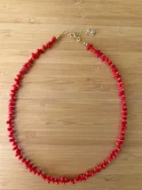 Gargantilla de coral rojo con cierre de mosquetón plateado y cadena de extensión.