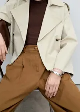 Pantalon de corte wide leg en color marrón, confeccionado en mezcla de algodón y lyocell. Presenta tiro medio, cierre frontal con cremallera y botón, trabillas para cinturón, bolsillos laterales y pinzas delanteras que aportan estructura.
