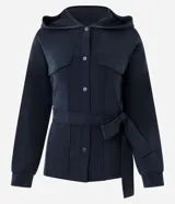 Campera deportiva de estilo utilitario color negro, confeccionada en tejido técnico. Presenta capucha, cierre frontal con botones, bolsillos con solapa en el pecho y lazo ajustable en la cintura. Posee mangas largas con puños y diseño liso.