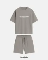 Conjunto de dos piezas compuesto por remera de corte oversize y bermuda a juego, confeccionado en algodón premium de alto gramaje. La remera presenta cuello redondo y estampado frontal con efecto desgastado, mientras que la bermuda cuenta con cintura elástica con cordón ajustable y diseño minimalista.