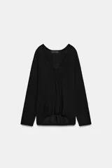 Jersey de punto fino negro con escote en V pronunciado, mangas largas y corte holgado con bajo asimétrico, más largo en la parte trasera.