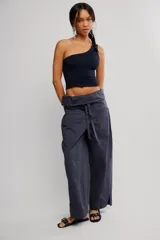 Top negro de un solo hombro, de calce ajustado y corte corto, confeccionado en punto elástico con costuras decorativas verticales.