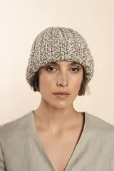 Gorro tejido a mano en punto grueso, con diseño de canalé y textura jaspeada en tonos neutros.