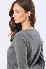 Saco tejido fino de hilo de algodón color beige, con cuello en V, cierre frontal con botones y puños acanalados.