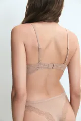 Conjunto de lencería compuesto por un soutien sin aro con detalles de encaje en el borde superior y una bombacha de corte clásico, ambos en color nude.
