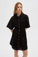 Vestido corto negro de algodón con diseño de broderie, cuello camisero, cierre frontal con botones y lazo ajustable en la cintura.