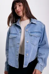 Sobrecamisa de jean azul con bolsillos frontales con solapa, cuello clásico y cierre de botones metálicos.
