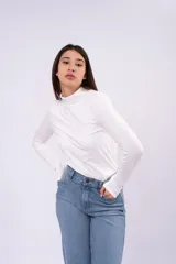 Polera de cuello alto bajo, manga larga, confeccionada en tejido liviano y elástico, con corte ajustado al cuerpo.
