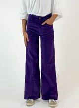 Pantalón de corte recto y tiro medio, confeccionado en pana color bordó. Presenta costuras verticales decorativas en el frente, cierre con botón y bolsillos laterales.