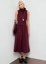 Vestido midi color bordó con diseño combinado, sin mangas, con tirantes anchos y cuello alto tipo embudo.