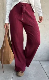 Pantalón de punto acanalado color bordó, con corte amplio y cintura elástica con cordón ajustable.