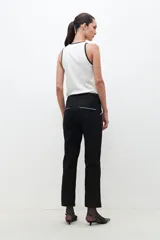 Pantalón negro de corte recto con vivo blanco en los laterales.
