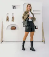 Borcego de cuero vacuno color negro, con suela de goma artesanal, caña alta con aplique capitoneado desmontable y horma de punta redonda.